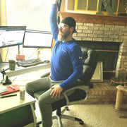 Testimonial picture working out at desk at home office doing seated military press